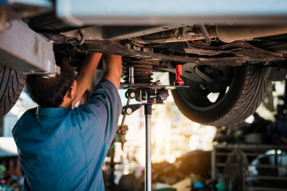 mechanic working on vehicle on lift